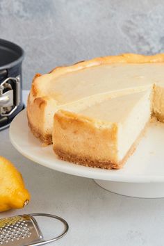 a cheesecake on a white plate with a slice cut out next to the rest of the cake