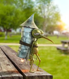 a small green insect standing on top of a wooden table