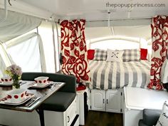 the interior of a camper with red and white decor