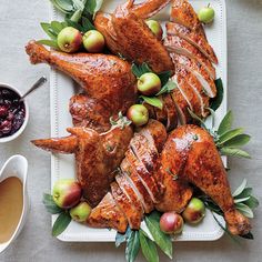 a platter filled with chicken, apples and cranberry sauce on top of a table