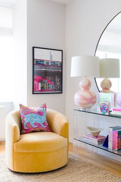 a living room filled with furniture and a large round mirror on the wall above it