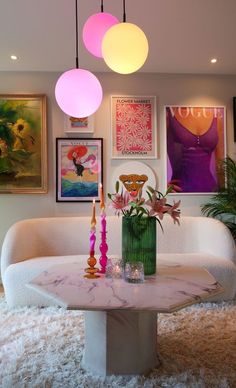 a living room filled with furniture and pictures on the wall above it's coffee table