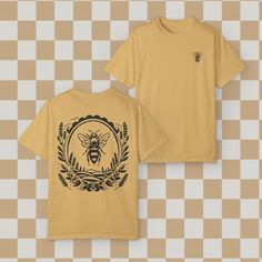 This comfort Colors tee made 100% with ring-spun cotton features a small bee on the front and a framed bee on the back! The soft-washed, garment-dyed fabric brings extra coziness to your wardrobe while the relaxed fit makes it an excellent daily choice. The double-needle stitching throughout the tee makes it highly durable while the lack of side-seams helps the shirt retain its tubular shape.  The Comfort Colors tee is made with medium fabric (6.1 oz/yd (206.8 g consisting of high quality, 100% Yellow Graphic T-shirt With Crew Neck, Vintage Cotton T-shirt With Front And Back Print, Yellow Crew Neck T-shirt With Screen Print, Vintage Crew Neck Top With Front And Back Print, Vintage Crew Neck T-shirt With Custom Print, Yellow Graphic Tee With Custom Print, Yellow Custom Print Graphic Tee, Graphic Tee With Front And Back Print, Bee Shirts