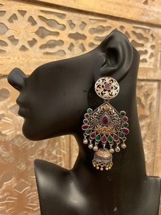 Gorgeous chandbali-jhumka design in pure brass (90%) and pure silver (10%) in two tone / dual tone / silver gold finish. Very beautiful design and craftsmanship. Available in red, blue, green, clear and multicolor stones.Care Instruction: Avoid heat & substances like perfume, deodorant, alcohol, etc and  clean with silver/gold polish cloth.Store in airtight spaces like ziplock pouch or jewelry box. Silver Dual-tone Bollywood Earrings, Bollywood Dual-tone Silver Earrings, Bollywood Style Dual-tone Silver Earrings, Silver Dual-tone Chandbalis For Diwali, Silver Dual-tone Temple Chandbalis, Silver Dual-tone Temple Jewelry Chandbalis, Silver Dual-tone Jhumkas For Diwali, Silver Dual-tone Temple Jewelry Jhumkas, Silver Dual-tone Chandbalis For Celebration