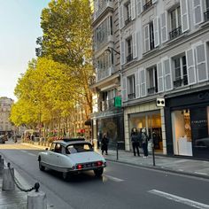 an old car is driving down the street