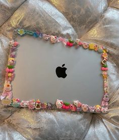 an apple laptop covered in lots of little cartoon characters