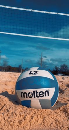 a volley ball sitting on top of a sandy beach