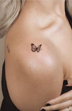 a woman's breast with a butterfly tattoo on her left shoulder and right breast