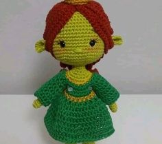 a crocheted doll with a red hair wearing a green dress and a yellow crown