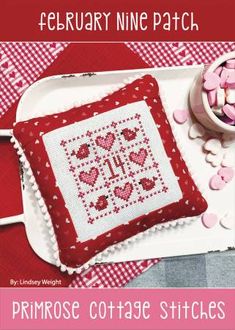 a cross stitch pillow with hearts on it and the text, february nine patch primrose cottage stitches