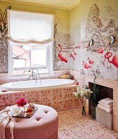 a bathroom decorated in pink and white with flamingos painted on the walls, along with a tub