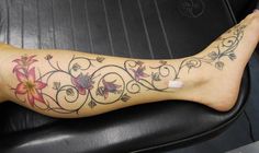 a woman's leg with flowers and vines on it