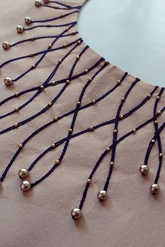 a close up of a dress with beads on it