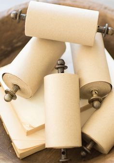 several rolls of toilet paper sitting on top of each other in a wooden bowl with metal handles