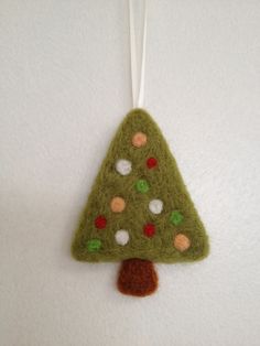 a felt christmas tree ornament hanging on a wall