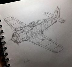 a drawing of an airplane is shown on a notebook with a pen in its hand