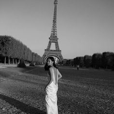 a woman standing in front of the eiffel tower