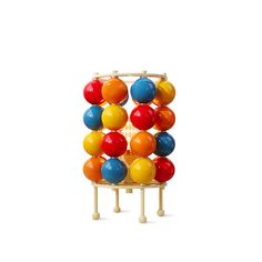 a multicolored wooden toy tower with balls on it's sides and two legs