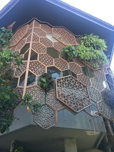 an intricate wooden building with plants growing out of the balconies on it's sides