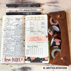 an open book with writing on it next to some markers and pencils sitting on top of a wooden table