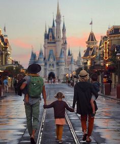 two adults and a child walking down the street in front of disney's castle