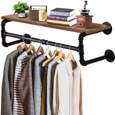 an iron pipe shelf with clothes hanging on it