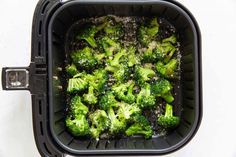 broccoli is being cooked in an air fryer with some seasoning on top