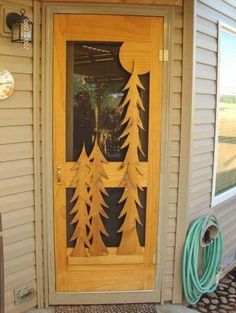 a wooden door with pine trees on it