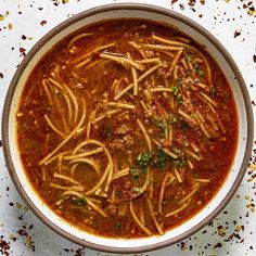 a bowl filled with pasta and meat soup