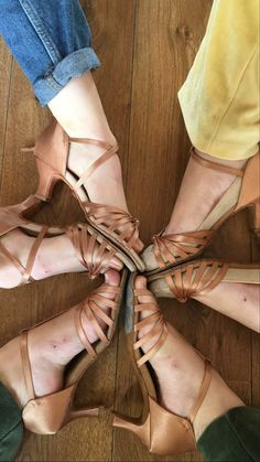 four pairs of women's shoes are arranged in a circle on a wooden floor