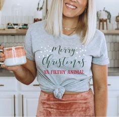 a woman holding a mug and smiling at the camera while wearing a t - shirt that says, may your coffee be longer than your toddler