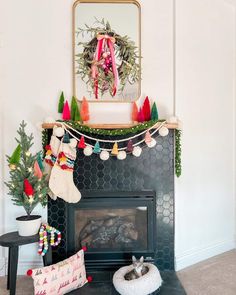 a fireplace decorated for christmas with stockings and garland