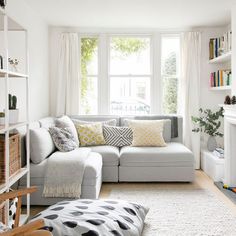 a living room filled with furniture and a fire place in front of a large window