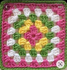 a crocheted square with white, yellow and pink flowers in the center is shown