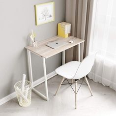 a white desk with a laptop on it next to a chair in front of a window