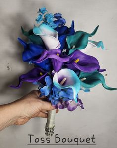 a hand holding a bouquet of blue and purple flowers