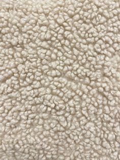 the texture of a white carpet is very soft and fluffy, with little bumps on it