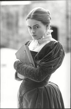 an old photo of a woman holding a book