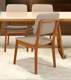 a dining room table with two chairs next to it and a vase on the other side