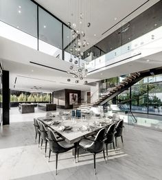 a large dining room table with chairs and a chandelier hanging from the ceiling