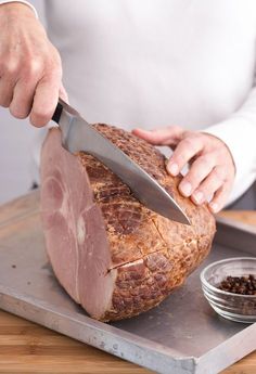 a person cutting meat with a large knife