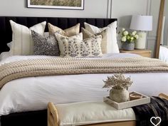 a bed with white sheets and pillows in a bedroom