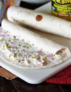 two burritos sitting on top of a white plate