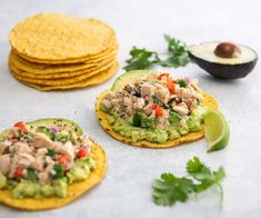 three tortillas with chicken, avocado and cilantro on them