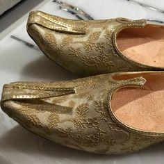 a pair of gold shoes sitting on top of a table