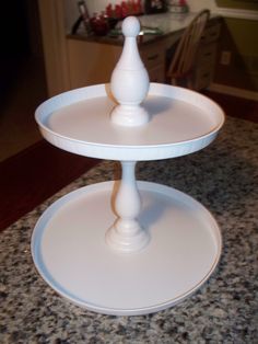 two tiered cake stand sitting on top of a counter