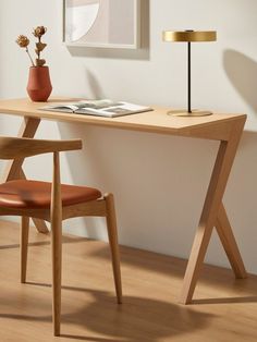 a wooden desk with a chair and lamp next to it