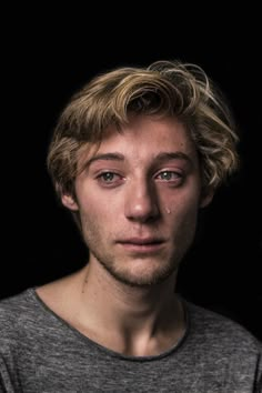 a man with blonde hair is looking at the camera