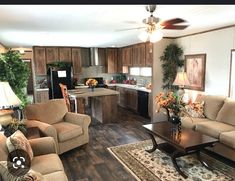 a living room filled with furniture next to a kitchen