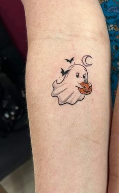 two people with matching tattoos on their arms, one has a ghost and the other has a pumpkin